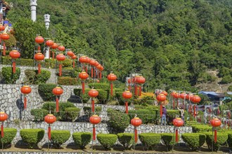 Stairs decorated with many lanterns and plants in the background of green mountains, Pattaya,