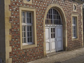 A brick façade with several windows and a large white door, Coesfeld, Münsterland, North