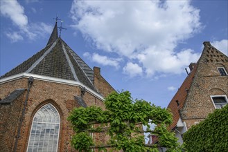 Red brick church with gothic architecture and high towers, someone in a village in good weather,