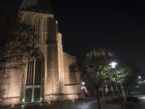 Church at night with illuminated street area and trees, bocholt, Münsterland, North