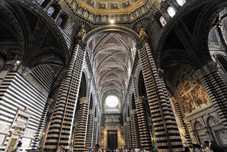The central nave of the cathedral with its black and white striped marble columns, cross and round