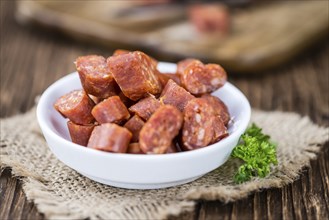 Chilli flavoured Sausages (German Mettwurst) on wooden background (selective focus)