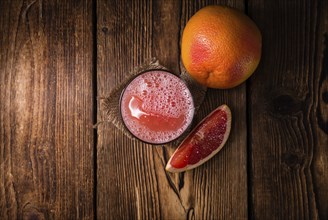 Freshly Squeezed Grapefruit Juice (close-up shot) on vintage wooden background