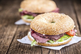 Bagel (with Roast Beef) on vintage background (selective focus, close-up shot)