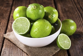Fresh Limes (detailed close-up shot) on wooden background (selective focus)