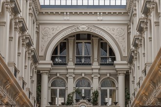 View of an ornate courtyard with colonnades and a glass roof that lets in light, The Hague,