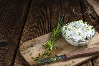 Homemade Herb Curd in bowl (close-up shot) on vintage wooden background