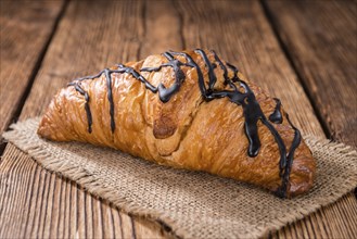 Fresh made Chocolate Croissants (close-up shot) on wooden background