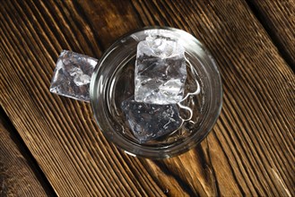 Vodka Shot with ice on an old rustic wooden table