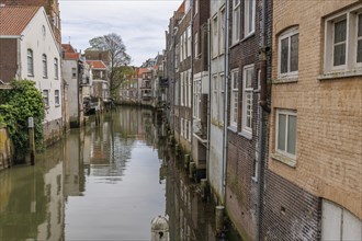 A quiet canal with houses on both sides whose facades are reflected in the water, Dordrecht,