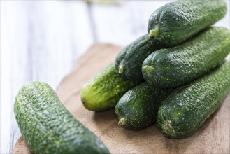 Some small Cucumbers (close-up shot) on vintage wooden background