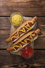 Homemade Hot Dog with ketchup and mustard on rustic wooden background