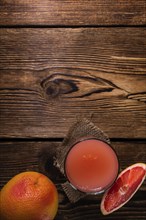 Freshly Squeezed Grapefruit Juice (close-up shot) on vintage wooden background