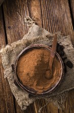 Portion of milled Cola Nut (close-up shot) on wooden background