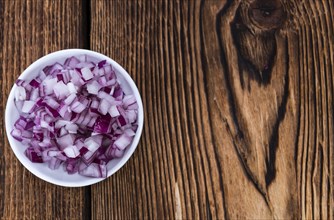 Some fresh Red Onions (diced) on an old wooden table