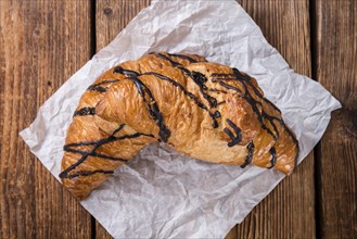 Fresh made Chocolate Croissants (close-up shot) on wooden background