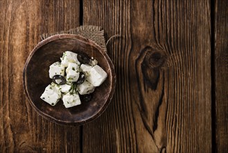 Greek Feta Cheese on rustic wooden background (close-up shot)