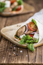 Chicken Wrap (close-up shot, selective focus) on vintage wooden background