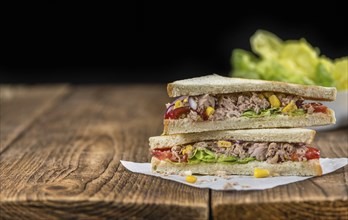 Wooden table with a fresh made Tuna Sandwich (selective focus, close-up shot)