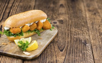 Fresh made Snack (Sandwich with Fish Sticks) on an old wooden table