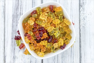 Bowl with Gummy Candy (selective focus) on wooden background