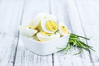 Halved Eggs on wooden background (close-up shot, selective focus)