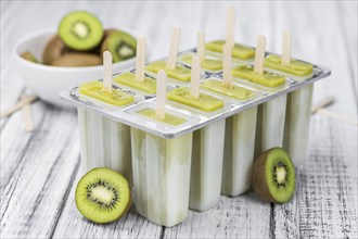 Kiwi Popsicles on an old wooden table (selective focus)