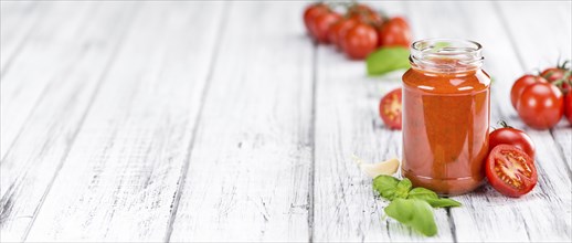 Pasta Sauce (Tomato taste) as high detailed close-up shot on a vintage wooden table (selective