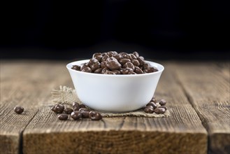 Old wooden table with Chocolate Raisins (close-up shot)