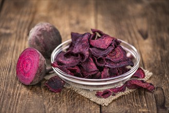 Wooden table with Beetroot Chips (detailed close-up shot, selective focus)