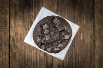 Vintage wooden table with Chocolate Muffins (selective focus, close-up shot)