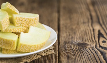 Honeydew Melon on an old wooden table as detailed close-up shot (selective focus)