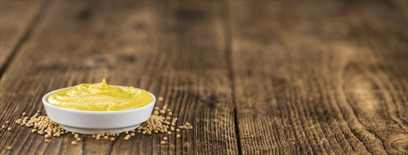 Mustard as high detailed close-up shot on a vintage wooden table (selective focus)