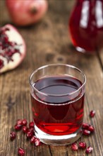 Pomegranate juice on a vintage background as detailed close-up shot (selective focus)