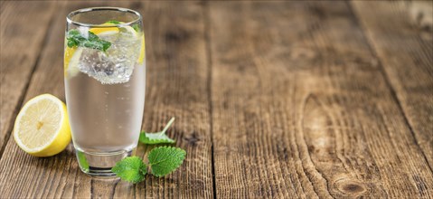 Homemade Lemonade on an wooden table (selective focus) as detailed close-up shot