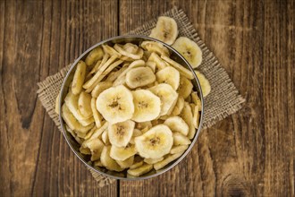 Fresh made Dried Banana Chips on an old and rustic wooden table, selective focus, close-up shot