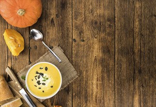 Homemade Pumpkin Soup (selective focus) on rustic background as close-up shot