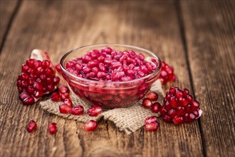 Vintage wooden table with preserved Pomegranate seeds (selective focus, close-up shot)