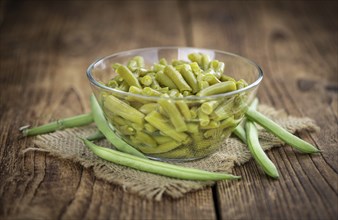 Preserved Green Beans as detailed close-up shot (selective focus) on vintage background