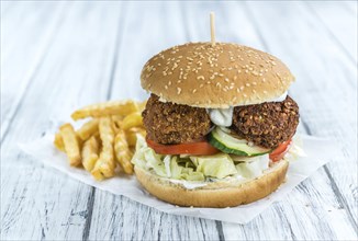 Fresh made Falafel Burger (close-up shot, selective focus) on wooden background