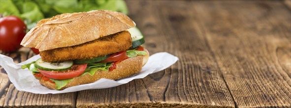 Fresh made Chicken Schnitzel on a bun (close-up shot, selective focus)