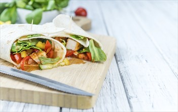 Portion of Chicken Wraps (selective focus) on an old wooden table