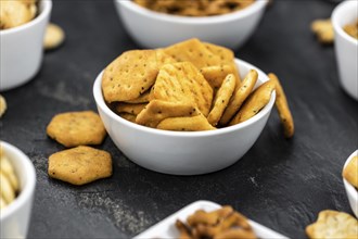 Portion of mixed Snacks on dark background (detailed close up shot, selective focus)