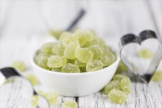 Portion of gummy candy (apple taste) on an old wooden table