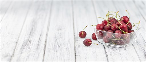 Cherries as high detailed close-up shot on a vintage wooden table, selective focus