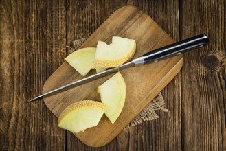 Honeydew Melon on an old wooden table as detailed close-up shot (selective focus)