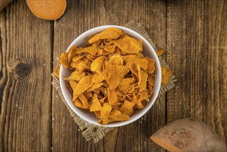 Sweet Potato Chips on a vintage background as detailed close-up shot, selective focus