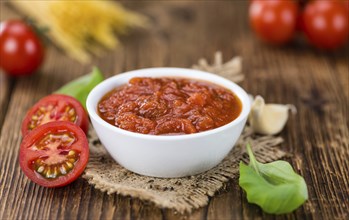 Tomato Sauce on rustic wooden background (close-up shot)