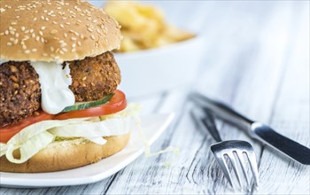 Fresh made Falafel Burger (close-up shot, selective focus) on wooden background