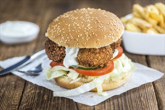 Fresh madeFalafel Burger on wooden background (close-up shot, selective focus)